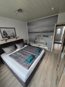 a bedroom with a bed and a painting of a ship at FeWo zwischen den Deichen in Emden