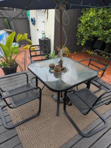 a table with two chairs and an umbrella on a patio at Casa Dorado - Bright, Sunny 2 Bedroom 1 Bath House - Fenced Yard, Private Patio in Santa Barbara