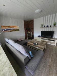 a living room with a couch and a television at FeWo zwischen den Deichen in Emden