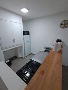 a kitchen with a stove and a wooden counter top at Deptosuno in General Roca +5 photos