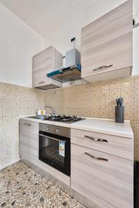 a kitchen with wooden cabinets and a stove top oven at Cozy Best Appartment in Marghera +25 photos