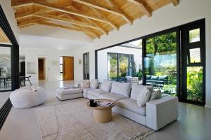 a living room with white furniture and large windows at Table Mountain and Constantiaberg view in Sweet Valley