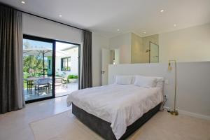a bedroom with a large bed and a sliding glass door at Table Mountain and Constantiaberg view in Sweet Valley