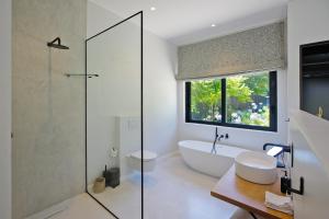 a bathroom with a tub and a glass shower at Table Mountain and Constantiaberg view in Sweet Valley +5 photos