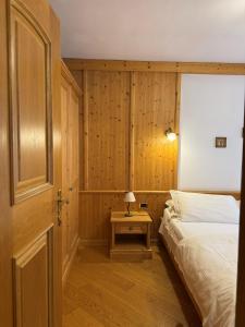 a bedroom with a bed and a table with a lamp at Campiglio Bilocale Dolomiti in Madonna di Campiglio