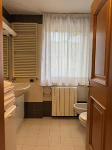 a bathroom with a sink and a toilet and a window at Campiglio Bilocale Dolomiti in Madonna di Campiglio +8 photos