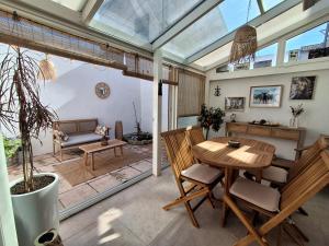a conservatory living room with a wooden table and chairs at Ch'ti Camargue in Port-Saint-Louis-du-Rhône