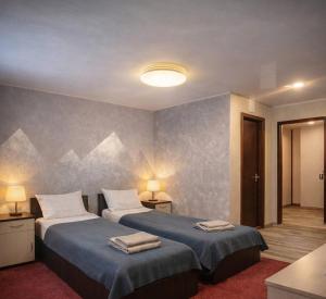 a bedroom with two beds with towels on them at Panorama H2O Self Check-in Pool in Korosten