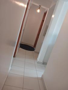 a hallway with a white tile floor and a light fixture at Buxton Point Classy 3BR in Mombasa