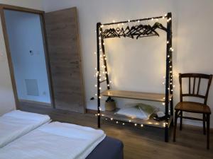 a bedroom with a mirror with lights and a chair at Le Charme de Colmar B&B in Colmar