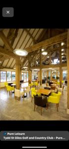 a lobby with tables and chairs and acountry club at par 3 in Wisbech