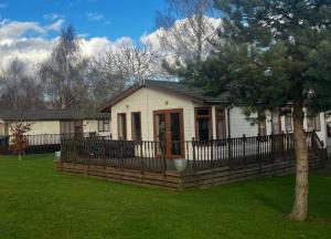 a small white house with a fence in a yard at par 3 in Wisbech