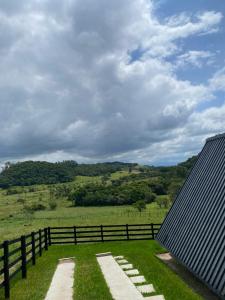 a house with a fence and a grass field at Refúgio do Morro - Cabana 1 in Torres +2 photos