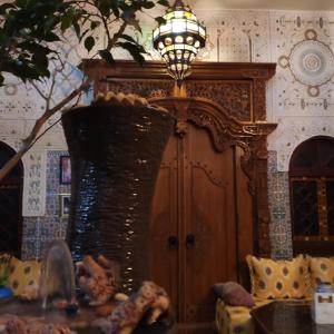 a living room with a chandelier and a couch and a table at Ryad Bab Berdaine in Meknès