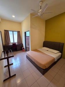 a bedroom with a bed with a ceiling fan at KRS Pines GuestHouse in Cameron Highlands