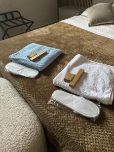 a bed with two towels and two slippers on it at Athens Air B&B in Athens