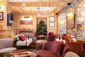 a christmas room with a christmas tree and chairs at Hotel La Chaudanne in Méribel