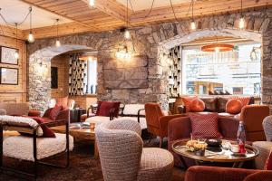 a restaurant with chairs and a stone wall at Hotel La Chaudanne in Méribel