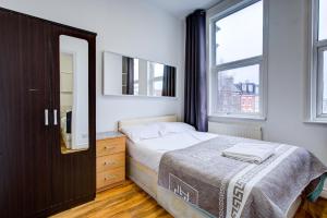 a bedroom with a bed and a large window at London Brompton Residence Hotel in London