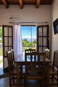 a dining room with a table and chairs and a window at Cabaña Regivan en Uspallata in Uspallata