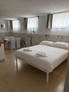 a white bed in a room with tables and chairs at da Melina in Parma