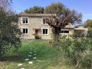 a stone house with a tree in the yard at Mas des Chênes - Charme et tranquillité au coeur de la Drôme Provençale in La Baume-de-Transit