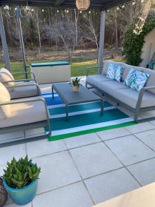 a patio with two couches and a table at Villa Caplanne in Sanguinet +4 photos