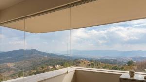 a room with a large window with a view of mountains at Eco-Loft Ixtapan de la Sal in Ixtapan de la Sal +3 photos