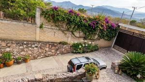 a car parked in front of a brick wall with flowers at Eco-Loft Ixtapan de la Sal in Ixtapan de la Sal