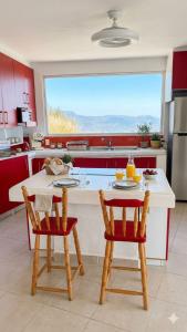 a kitchen with red cabinets and a table with two chairs at Eco-Loft Ixtapan de la Sal in Ixtapan de la Sal