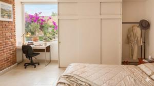 a bedroom with a bed and a desk and a window at Eco-Loft Ixtapan de la Sal in Ixtapan de la Sal