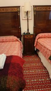 a bedroom with two beds and a lamp on a rug at Precioso Piso junto a Plaza de España in Seville