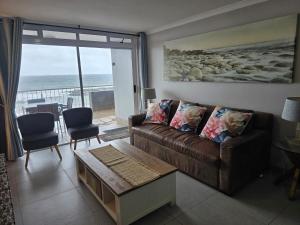a living room with a couch and a view of the ocean at Flat 108 Cozumel, Umdloti Beach Front in Umdloti