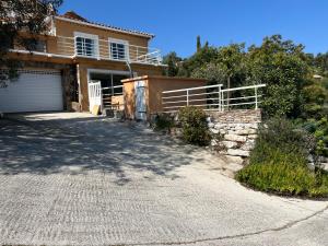 a driveway leading to a house with a garage at Ou Souleou appartement 3 étoiles dans villa Spa béton jardin vue mer et colline in Bormes-les-Mimosas