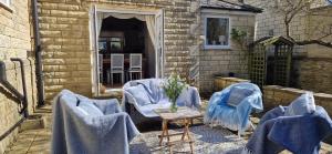 a patio with blue chairs and a table with towels at Rockleigh House in Corsham