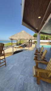 a patio with chairs and umbrellas on the beach at Casa la barra surf resort in Miramar