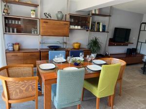 a dining room with a wooden table and chairs at Ou Souleou appartement 3 étoiles dans villa Spa béton jardin vue mer et colline in Bormes-les-Mimosas