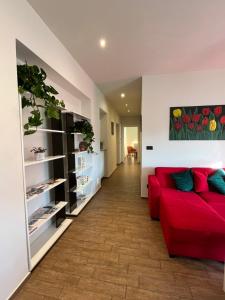 a living room with a red couch and shelves at Alba in Fiore in Alba +22 photos