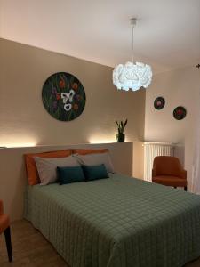 a bedroom with a green bed and a chandelier at Alba in Fiore in Alba
