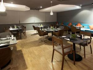 a restaurant with tables and chairs in a room at Novotel Santos Gonzaga in Santos