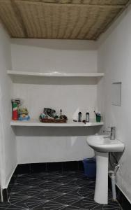 a bathroom with a sink and a counter with a toilet at Demba Dou Suites Gardens in Batukunku