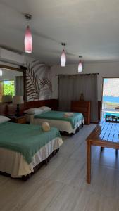 a hotel room with two beds and a table at Casa la barra surf resort in Miramar