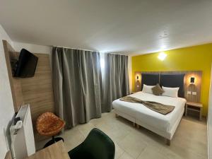 a bedroom with a bed and a tv in it at NOROTEL Eco in Brumath