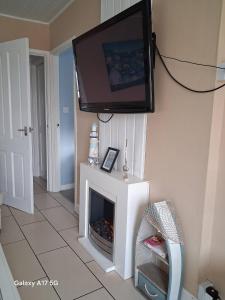 a living room with a fireplace with a tv on the wall at Sandcastle Chalet in Bridlington +5 photos