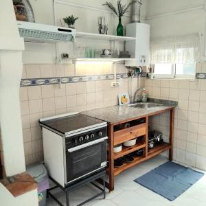 a kitchen with a stove and a sink at Anexo na Quintinha in Caldas da Rainha