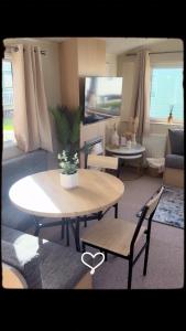 a living room with a table and chairs at Sundaes caravan rental in Kinmel Bay