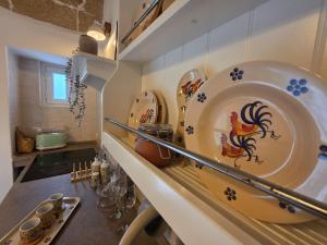 a kitchen with a counter with plates on the wall at La Chicca di Fiore - Guest House in Gallipoli