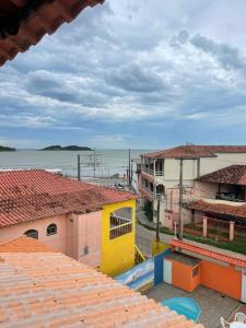 a view of the ocean from the roofs of buildings at Pousada Mirante do Sol in Piúma