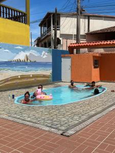a group of people in a swimming pool at Pousada Mirante do Sol in Piúma +10 photos
