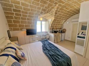 a bedroom with a large bed with a stone wall at La Chicca di Fiore - Guest House in Gallipoli